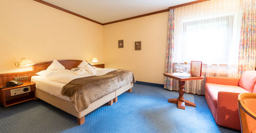 A double bed in a hotel room at Rindererhof