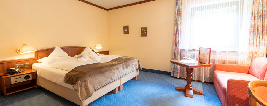 Ein Doppelbett in einem Hotelzimmer im Rindererhof