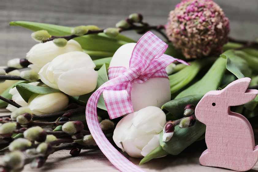 Easter decoration with flowers, eggs and a bunny made of wood