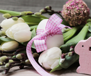 Easter decoration with flowers, eggs and a bunny made of wood