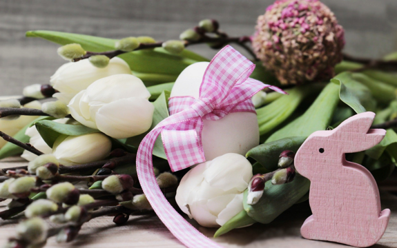 Easter decoration with flowers, eggs and a bunny made of wood