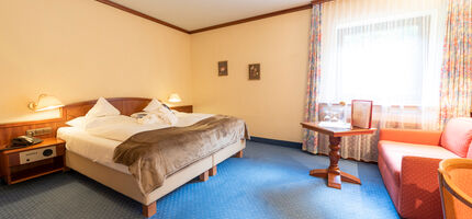 A double bed in a hotel room at Rindererhof