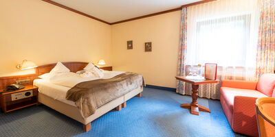 A double bed in a hotel room at Rindererhof